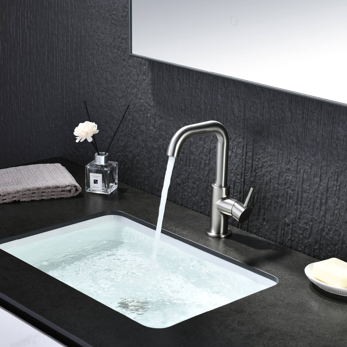 Aquavit Circular brushed nickel basin faucet AT090711 in dark bathroom setting