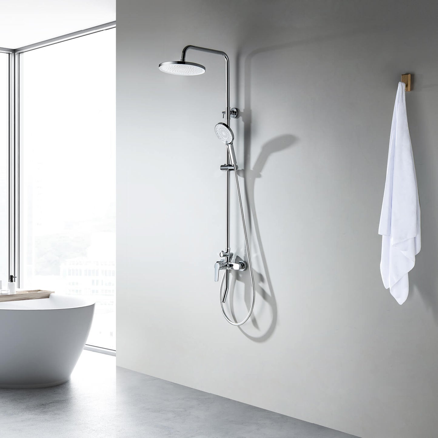 Aquavit Sense chrome three-outlet shower column beside a freestanding bathtub