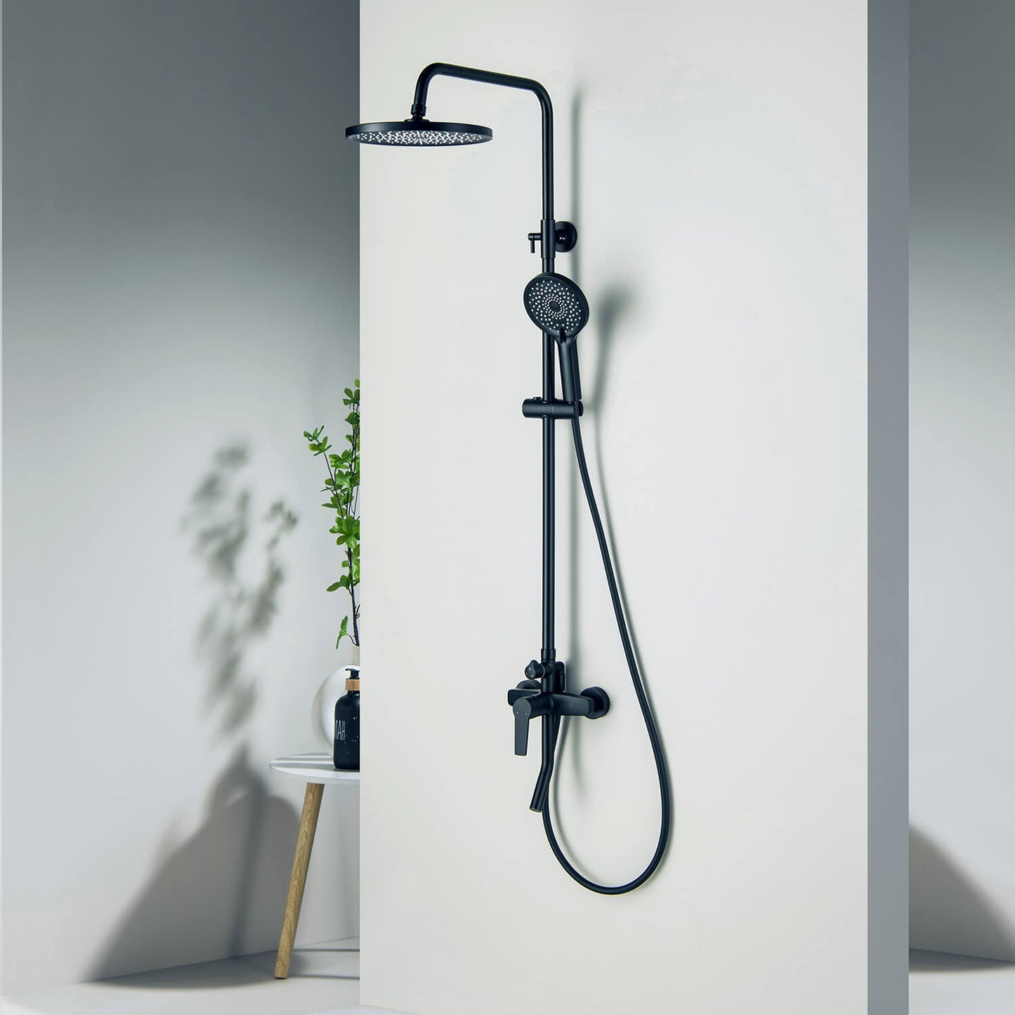 Aquavit Sense matte black three-outlet shower column installed beside a wall niche